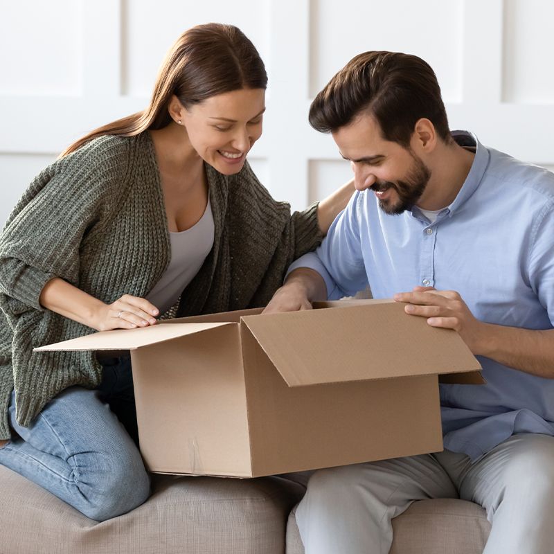 Pärchen packt ein Paket aus.